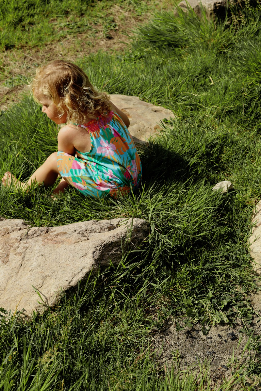 Kind speelt buiten in het hoge gras