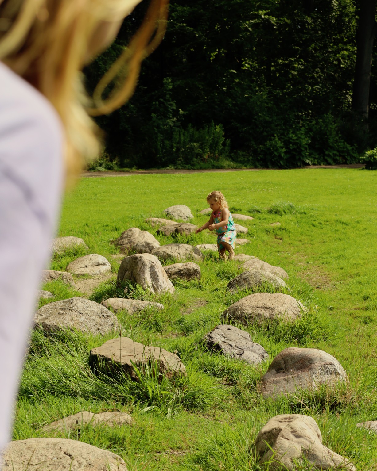Twee volwassenen lopen samen door een zonnig veld